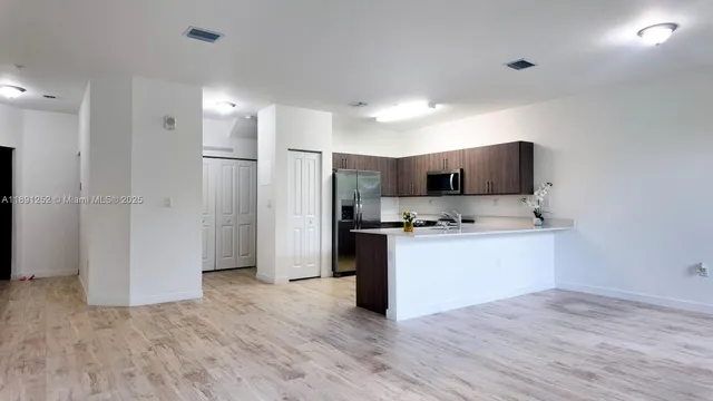a kitchen with a refrigerator and a stove top oven