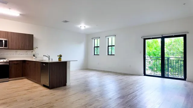 a kitchen with wooden floors and windows