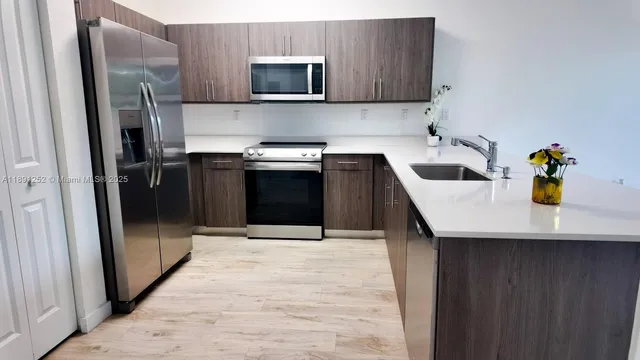 a kitchen with a sink and stainless steel appliances