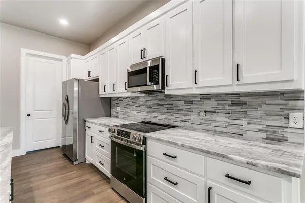 a kitchen with granite countertop a sink and stainless steel appliances