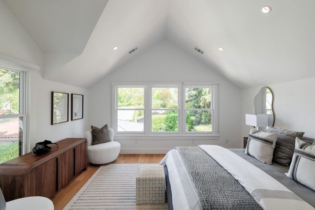 a spacious bedroom with a bed a couch and a window