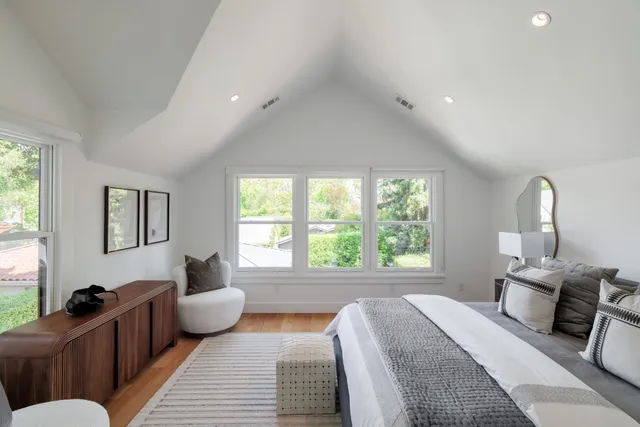 a spacious bedroom with a bed a couch and a window