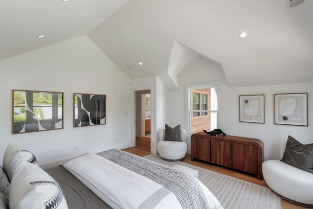 a spacious bedroom with a bed couch and window