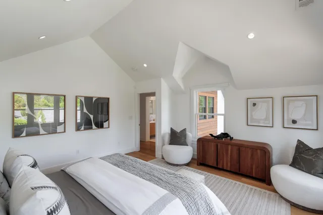 a spacious bedroom with a bed couch and window