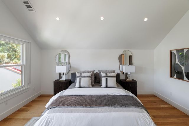 a bedroom with a bed and wooden floor