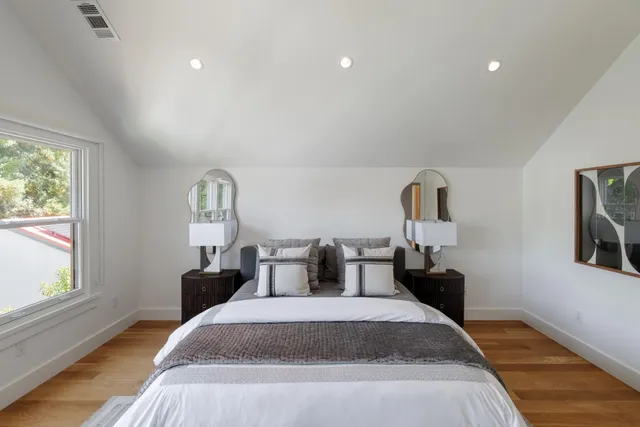 a bedroom with a bed and wooden floor