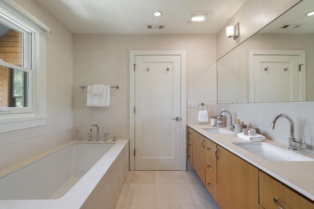 a bathroom with a tub sink and mirror