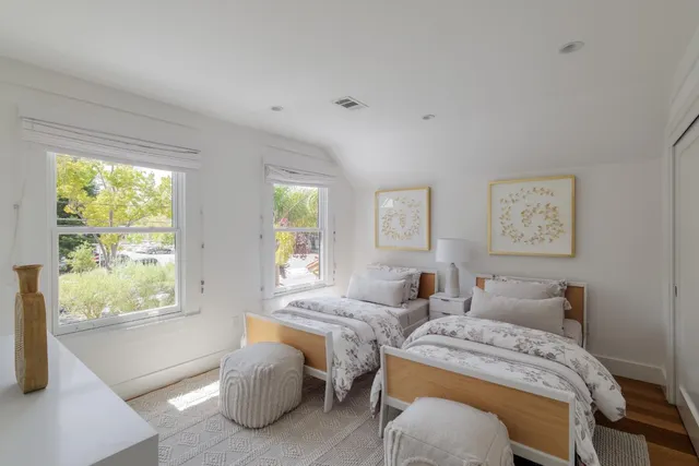 a bedroom with two beds and a large window