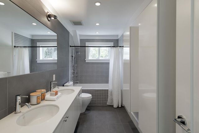 a bathroom with a tub sink and mirror