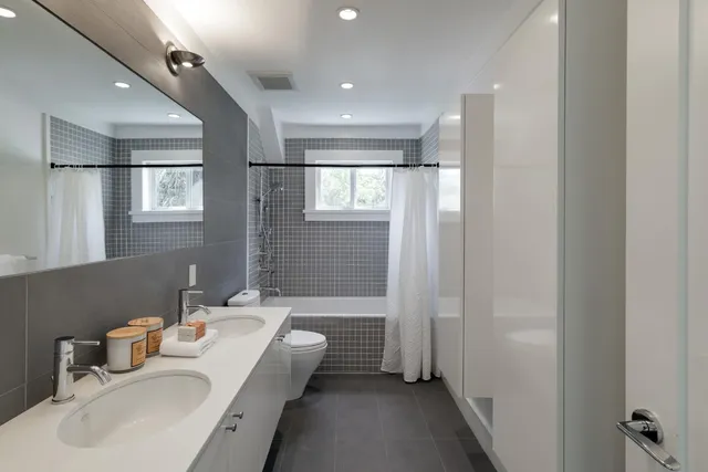 a bathroom with a tub sink and mirror