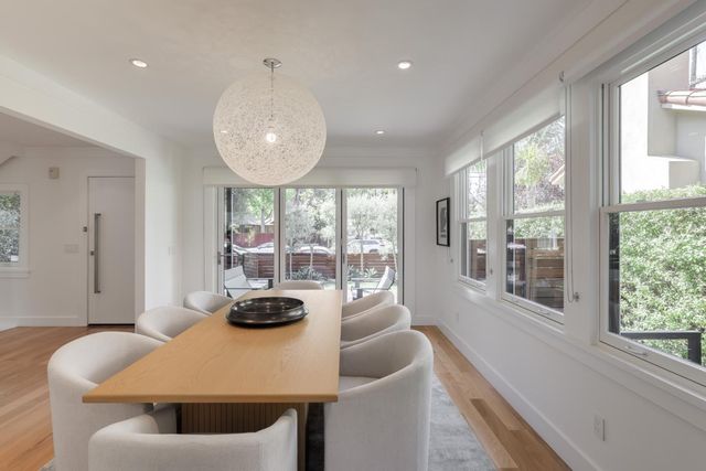 a view of a dining room with furniture large windows and wooden floor