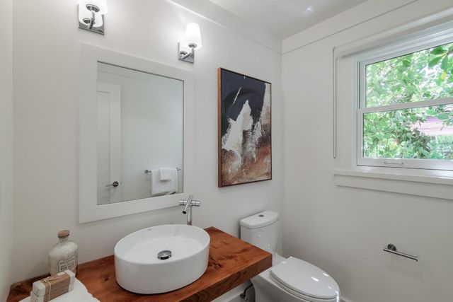 a bathroom with a sink a toilet and mirror