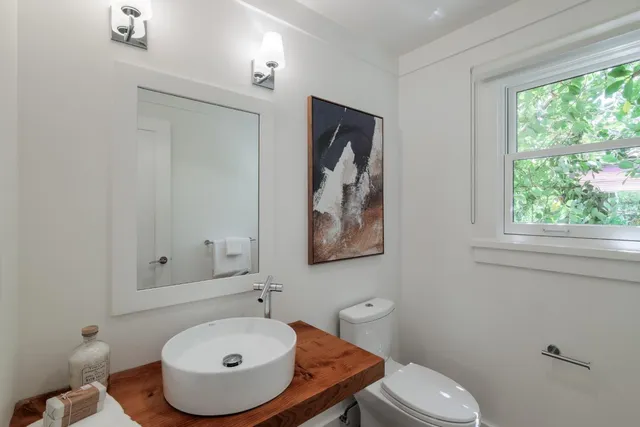 a bathroom with a sink a toilet and mirror