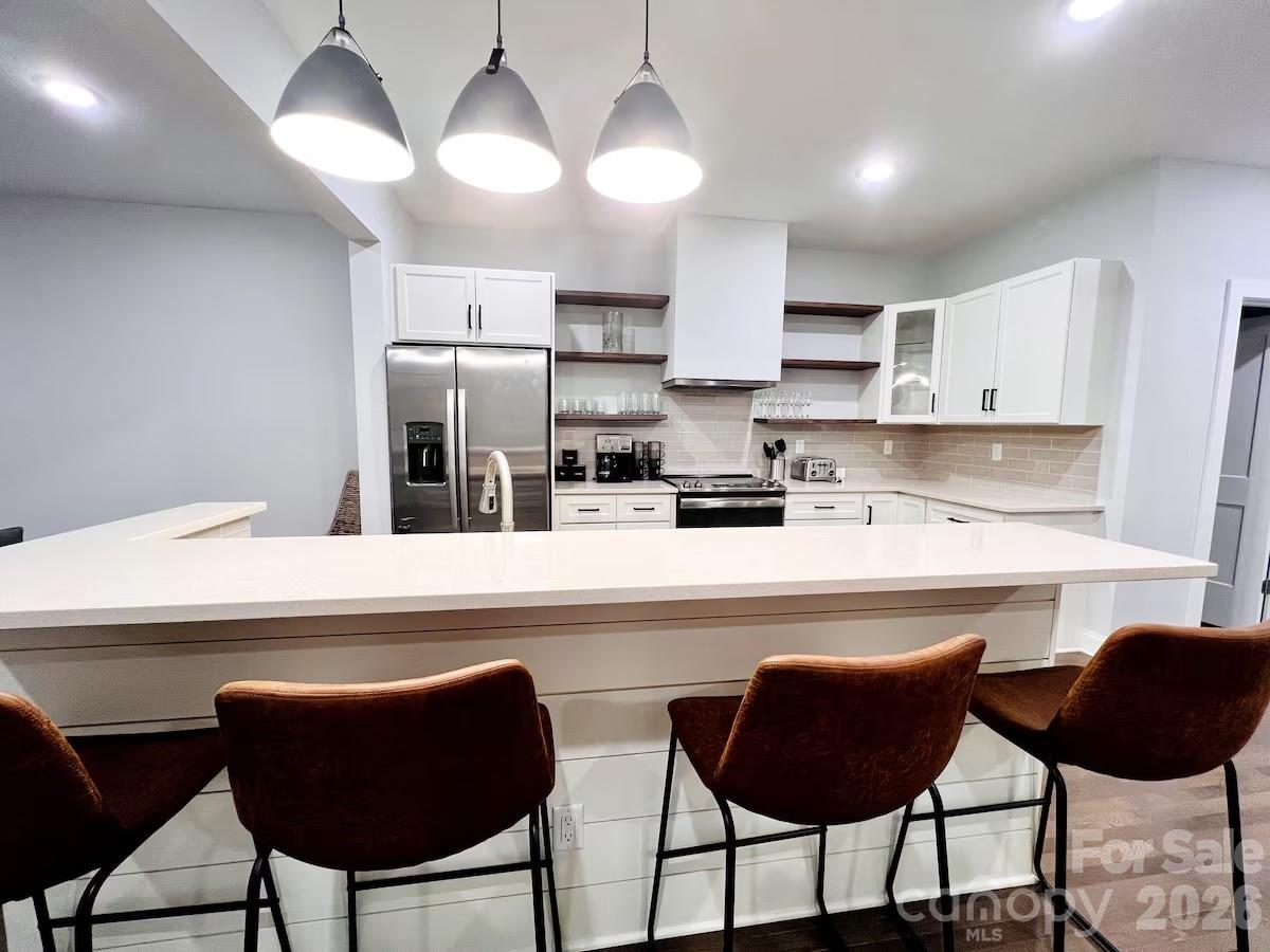 1063 Riverside Drive Asheville, NC 28804 - Photo 22 of 40 a kitchen with stainless steel appliances kitchen island granite countertop a dining table chairs and a refrigerator