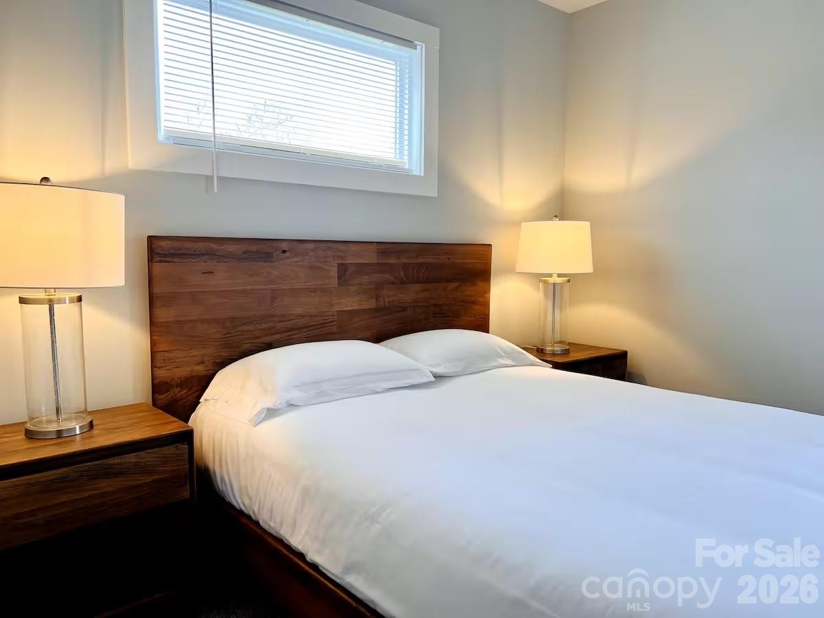 1063 Riverside Drive Asheville, NC 28804 - Photo 25 of 40 a bed sitting in a bedroom next to a window