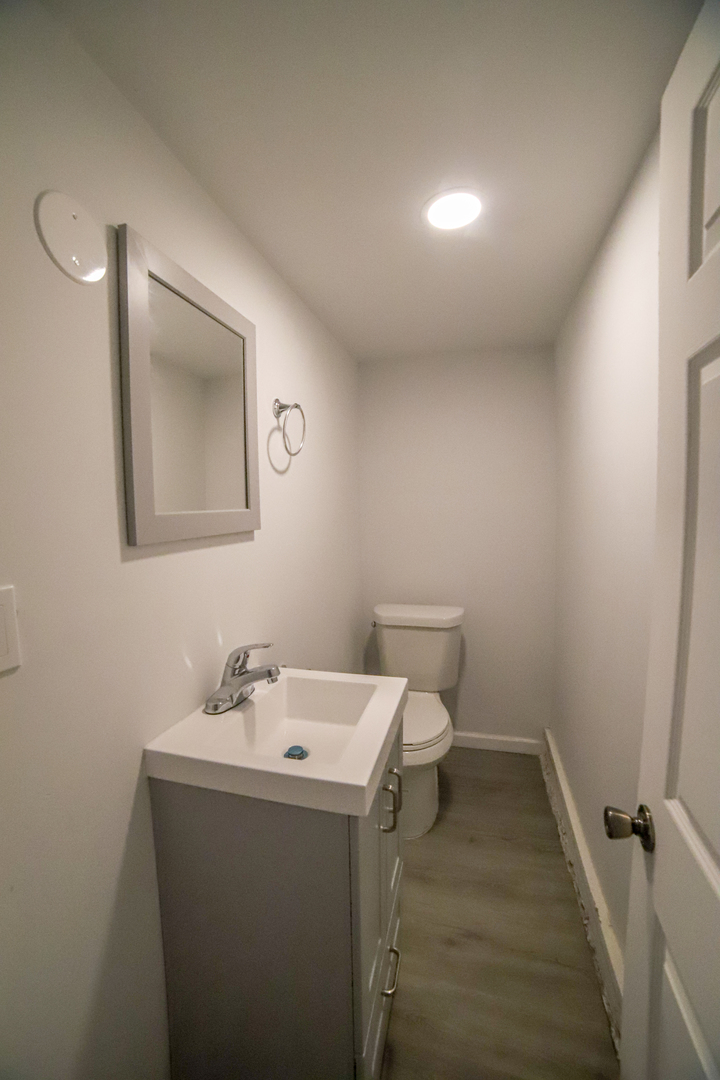 1127 North Ridgeway Avenue Chicago, IL 60651 - Photo 20 of 24 a bathroom with a sink mirror and toilet