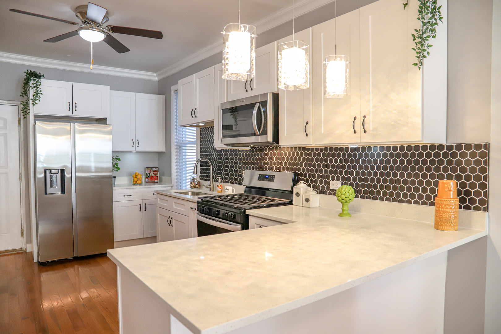1127 North Ridgeway Avenue Chicago, IL 60651 - Photo 7 of 24 a kitchen with stainless steel appliances a sink a stove a refrigerator cabinets and a window