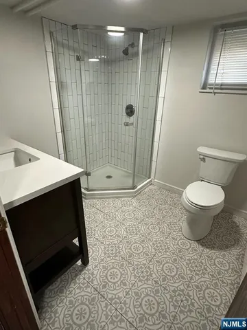 a bathroom with a sink a toilet a mirror and shower