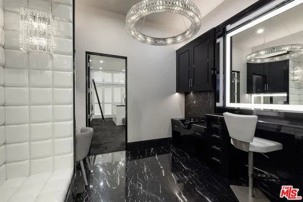 a spacious bedroom with a bed and a chandelier
