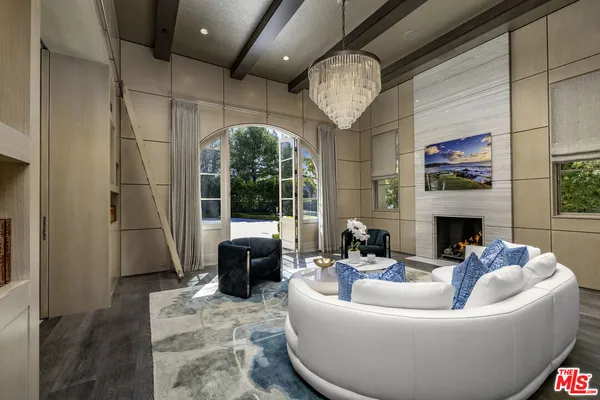 a living room with furniture a fireplace and a large window