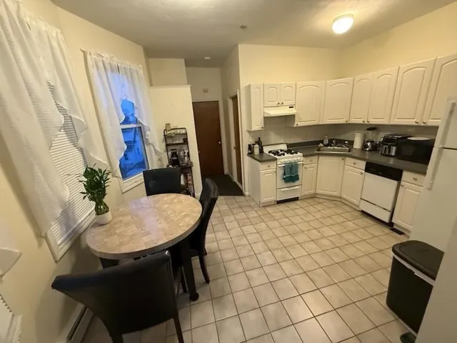 a kitchen with stainless steel appliances granite countertop a sink a stove a refrigerator a microwave oven with white cabinets and granite countertops