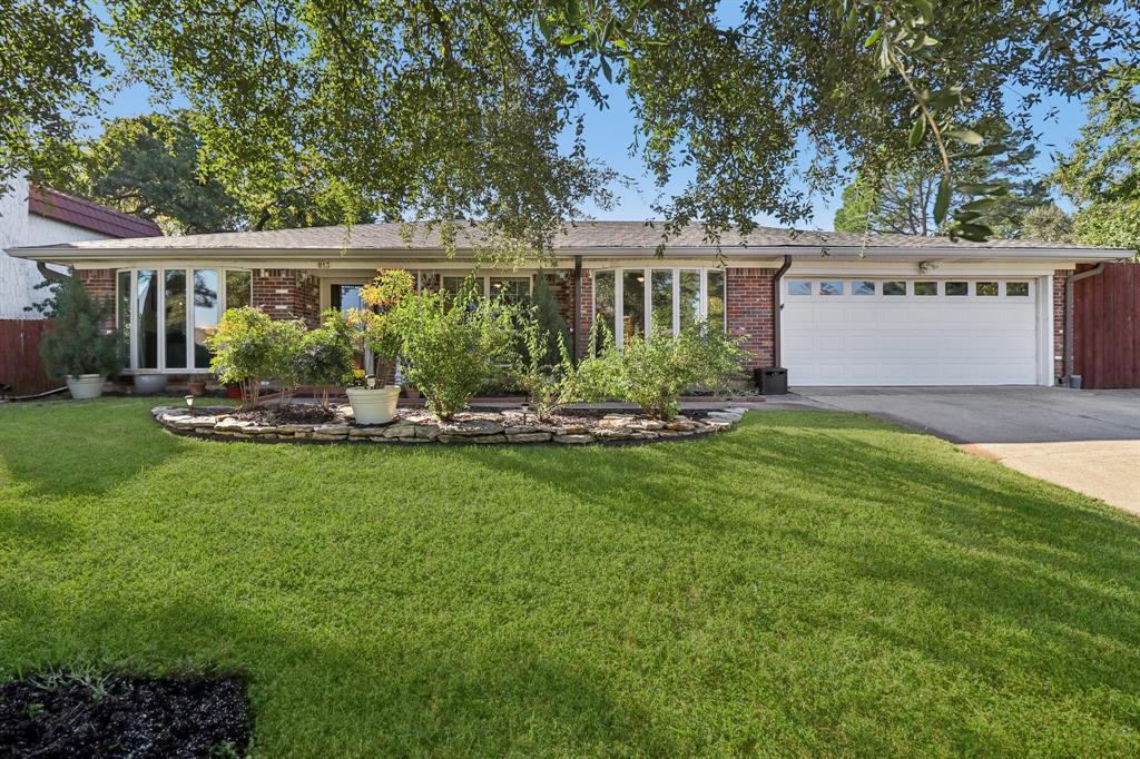 a front view of a house with a yard garden and outdoor seating