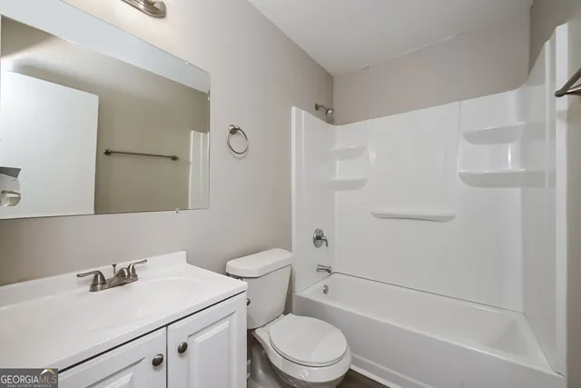 a bathroom with a sink toilet vanity and shower