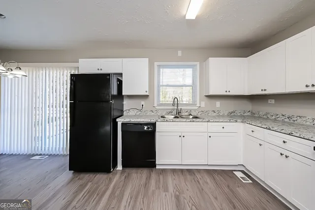 a kitchen with a refrigerator sink and cabinets