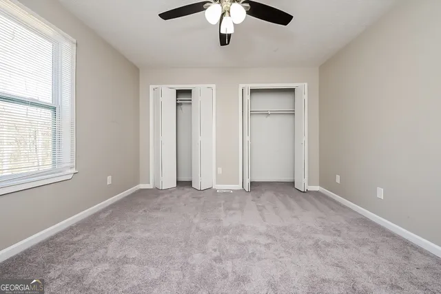 an empty room with windows and cabinet