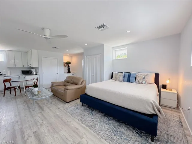 a spacious bedroom with a bed a table and chairs