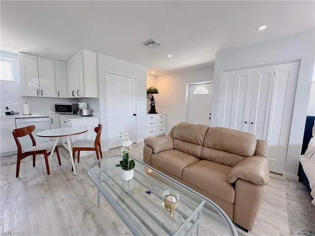 a kitchen with stainless steel appliances kitchen island hardwood floor and a sink