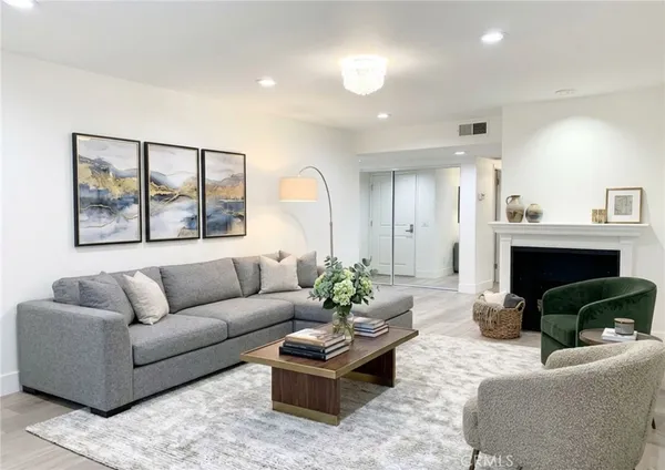 a living room with furniture a fireplace and a large mirror