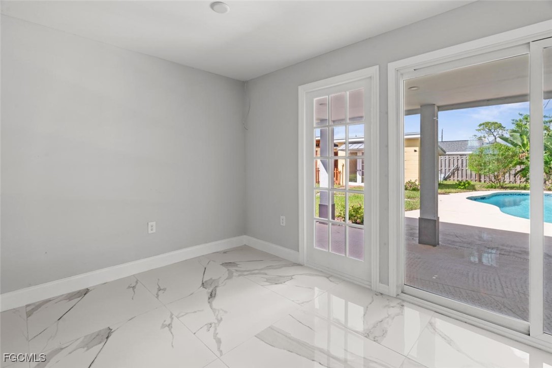 4970 Riverside Drive Estero, FL 33928 - Photo 12 of 35 a view of an empty room with wooden floor and a window