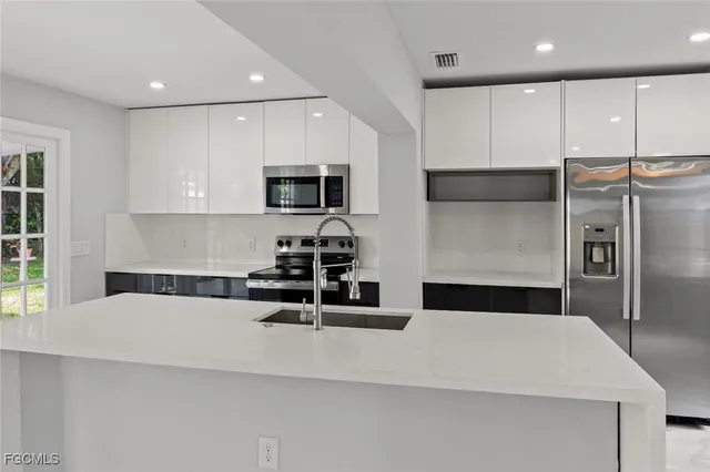 a kitchen with stainless steel appliances a refrigerator sink and microwave