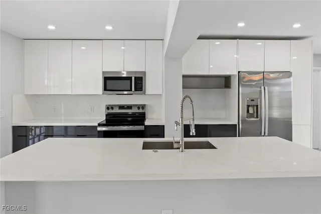 a kitchen with stainless steel appliances a stove microwave and sink