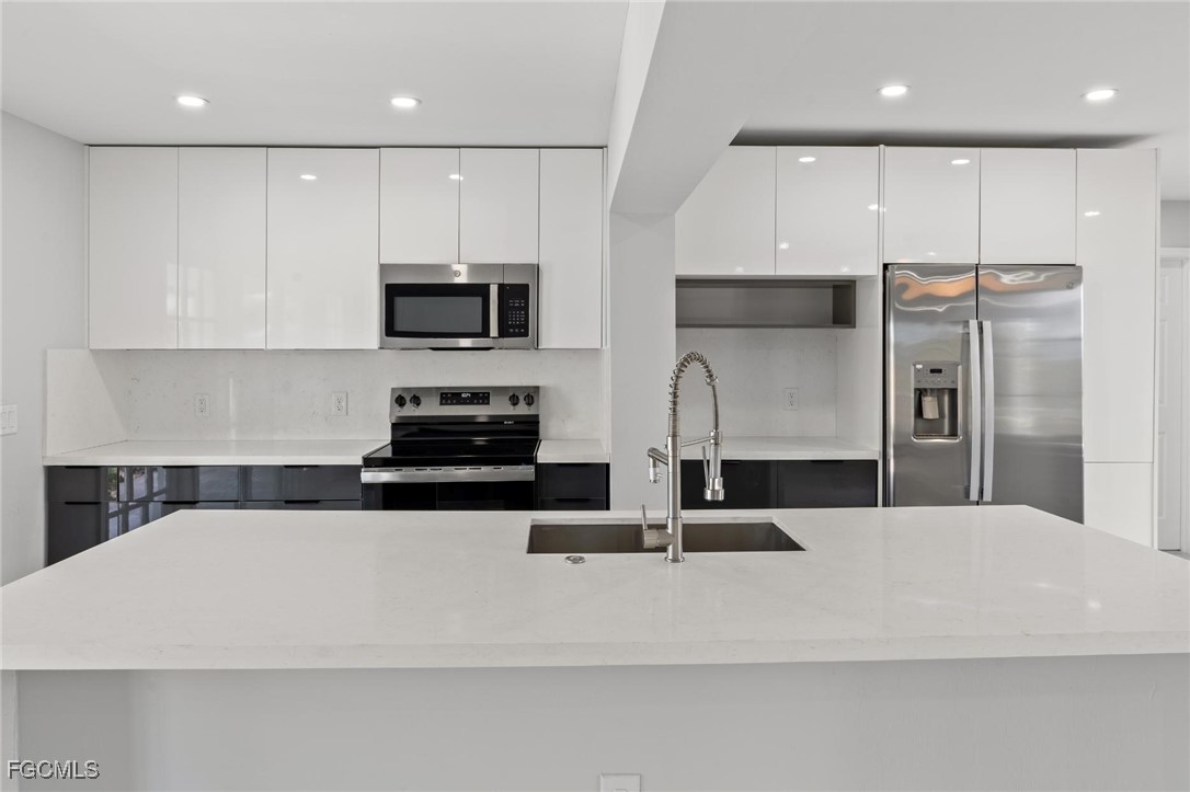 4970 Riverside Drive Estero, FL 33928 - Photo 17 of 35 a kitchen with stainless steel appliances a refrigerator sink and microwave