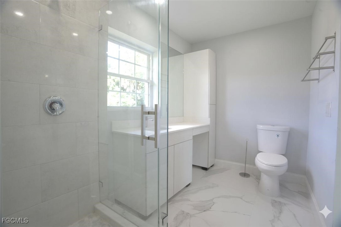 4970 Riverside Drive Estero, FL 33928 - Photo 22 of 35 a bathroom with a toilet sink and shower