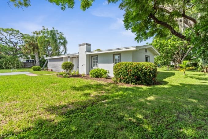 4970 Riverside Drive Estero, FL 33928 - Photo 25 of 35 a front view of a house with garden