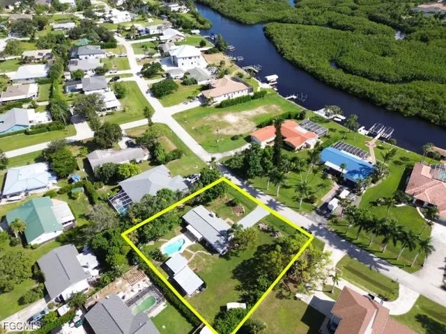 an aerial view of residential houses with outdoor space and trees