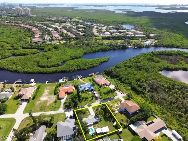 an aerial view of a house with swimming pool and large trees