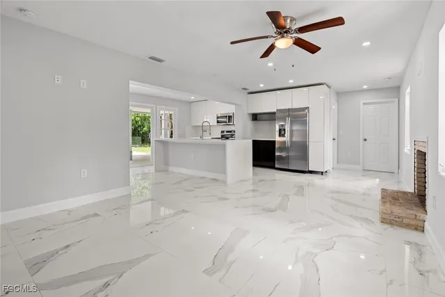 a kitchen with kitchen island a large counter top space a sink stainless steel appliances and cabinets