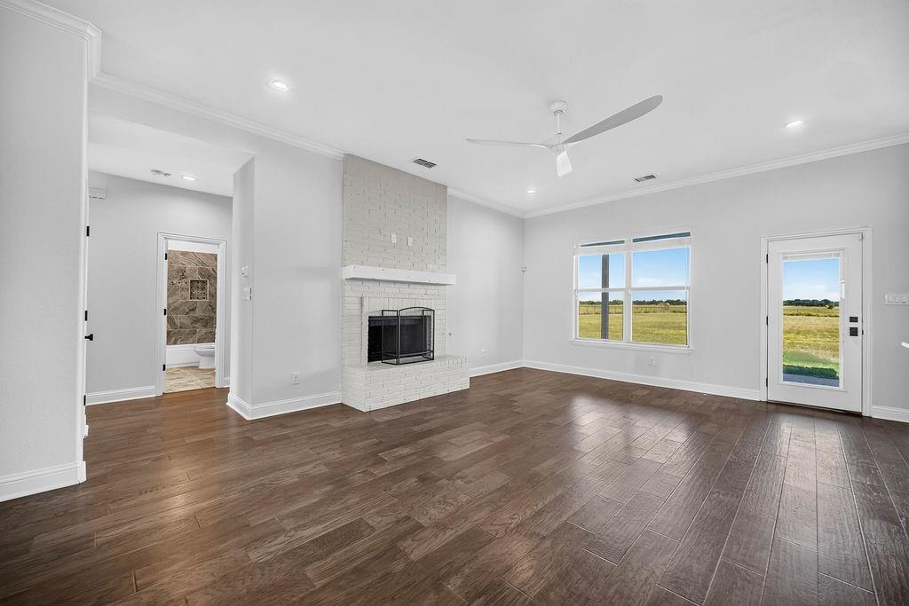 544 Gant Road Sherman, TX 75090 - Photo 13 of 39 Spacious living area featuring wood-finish flooring, a white brick fireplace, a ceiling fan, and recessed lighting