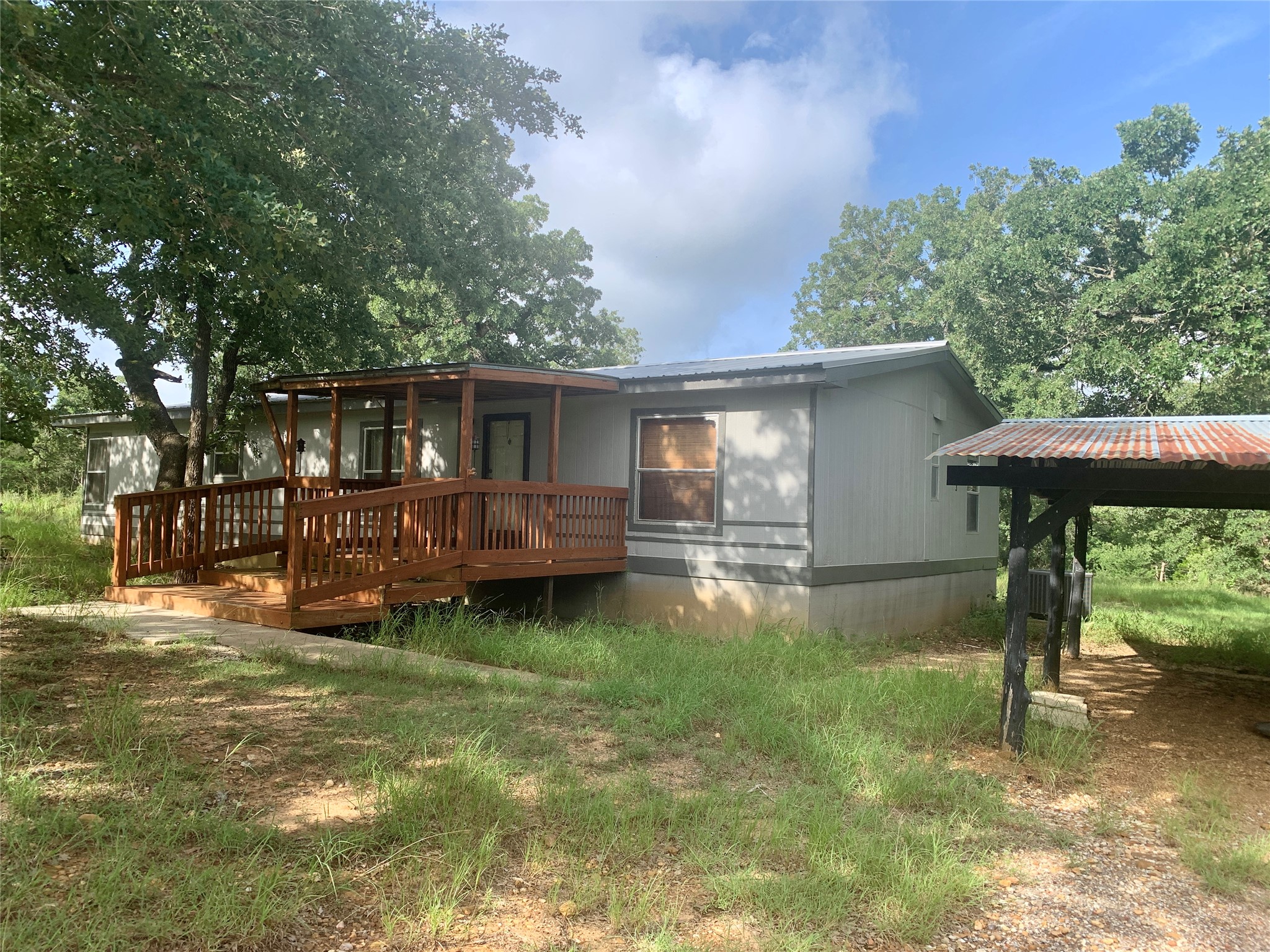 910 Antioch Road Paige, TX 78659 - Photo 1 of 1 Front of house featuring a metal roof and a deck
