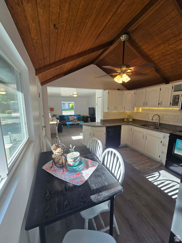 259 14th Street Ogden, UT 84404 - Photo 9 of 21 Open-concept kitchen and dining area featuring a vaulted wood-plank ceiling, white cabinetry with under-cabinet lighting, a central kitchen island, and wood-finish flooring
