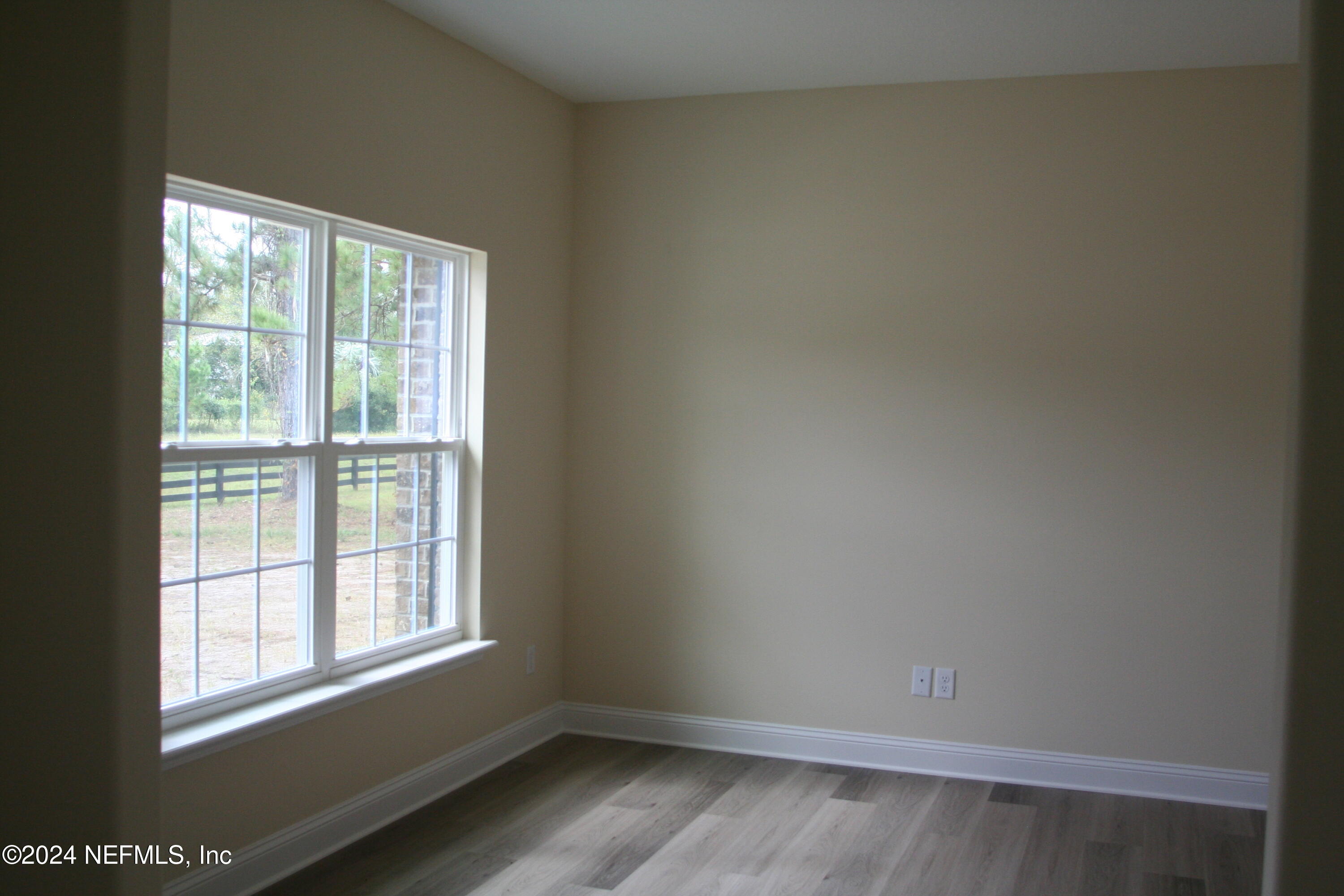 54835 Dornbush Road Callahan, FL 32011 - Photo 4 of 31 an empty room with wooden floor and windows