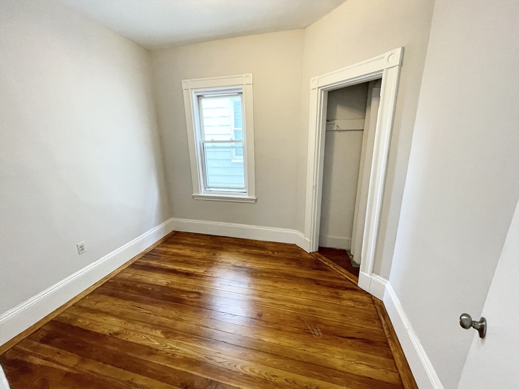 10 Wave Avenue, Unit 2 Boston, MA 02125 - Photo 11 of 15 a view of an empty room with wooden floor and a window