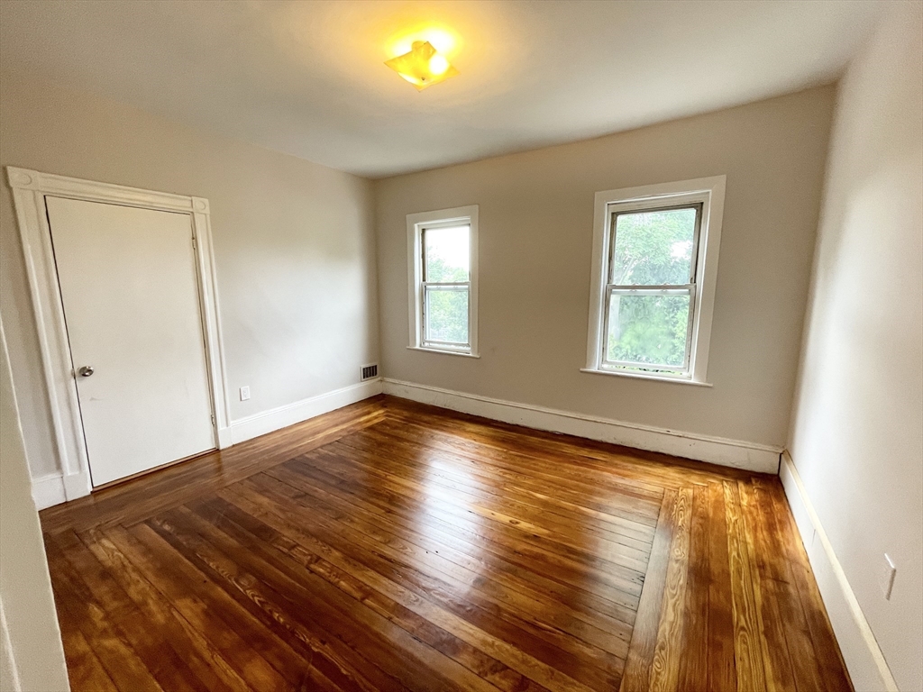 10 Wave Avenue, Unit 2 Boston, MA 02125 - Photo 13 of 15 a view of empty room with wooden floor and fan