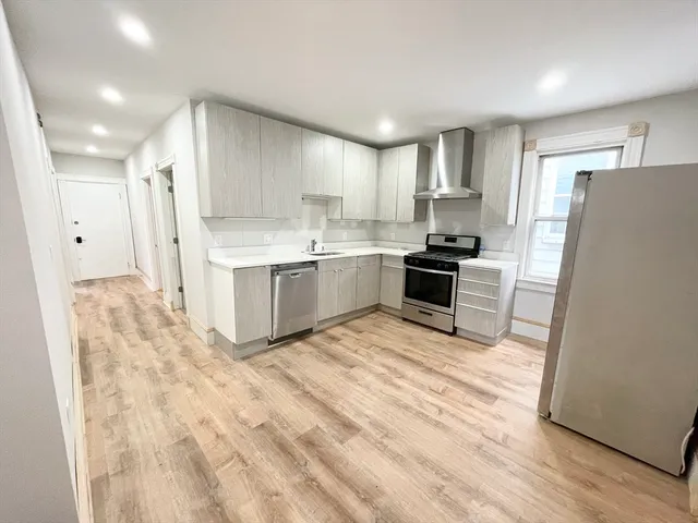 a kitchen with stainless steel appliances granite countertop a refrigerator a stove and a sink