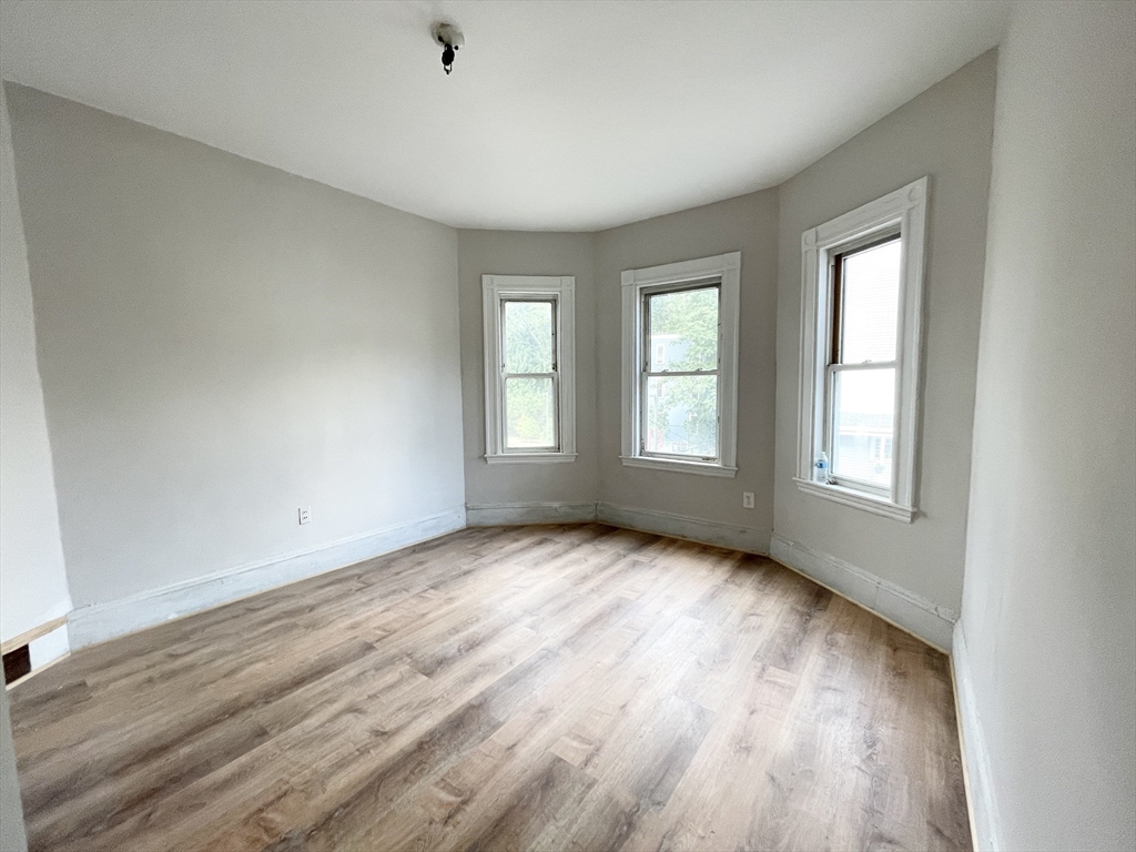 10 Wave Avenue, Unit 2 Boston, MA 02125 - Photo 4 of 15 a view of an empty room with wooden floor and window