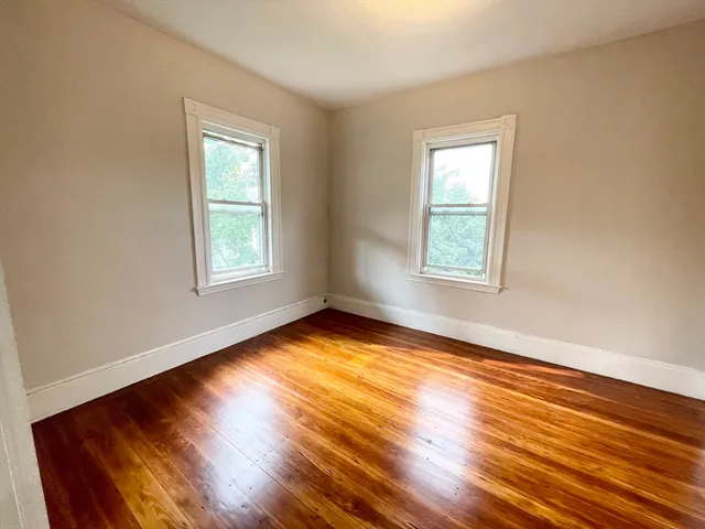 a view of a room with wooden floor and windows